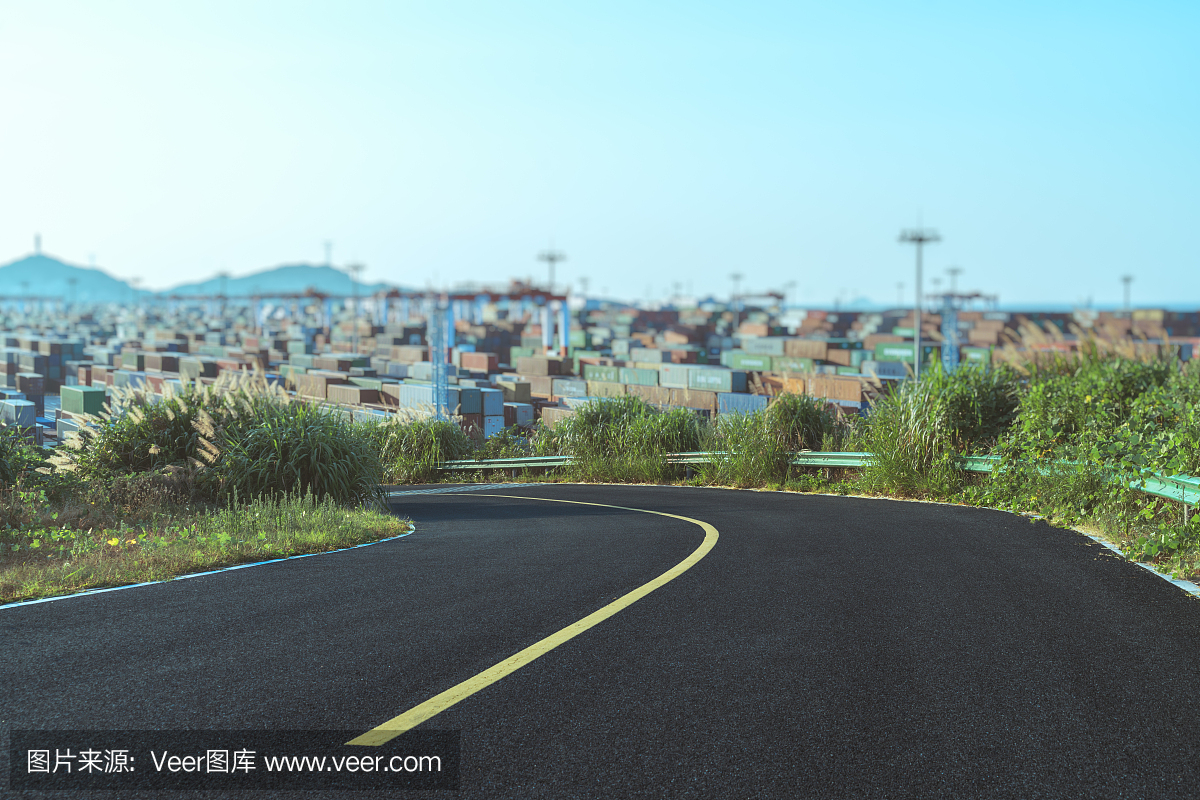 空蕩蕩的高速公路,背景是一個(gè)工業(yè)港口